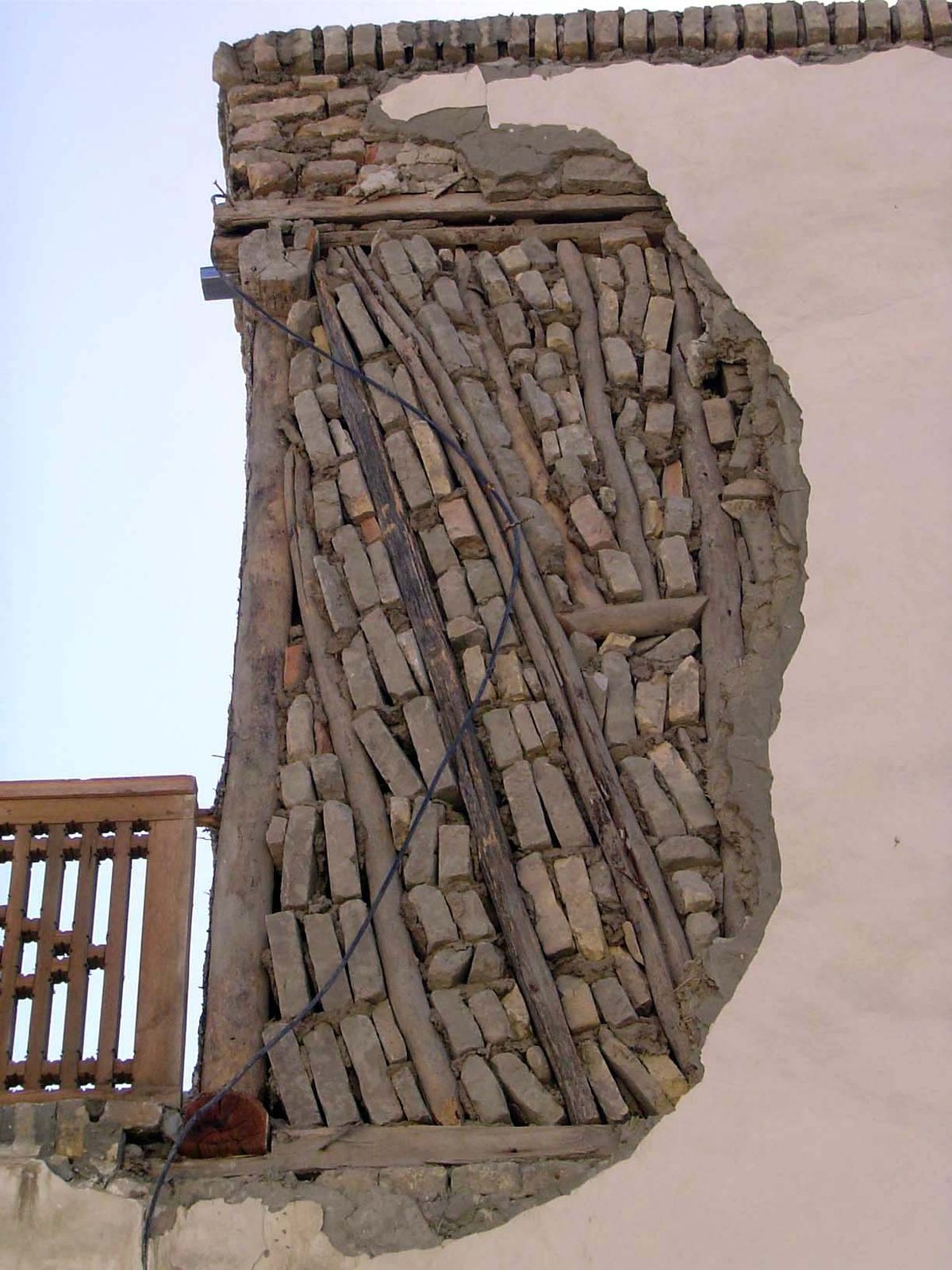 Around it are buildings with the classic Uzbek wood-frame wall, loosely filled with adobe bricks guwalyak.