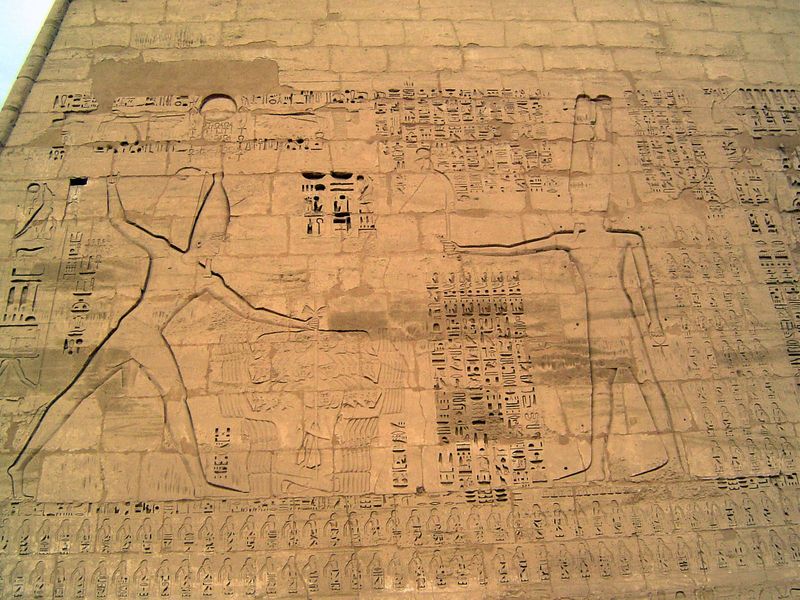 On the face of the first pylon is this image of Ramesses III holding his enemies by the head and offering them to Amun, who holds a short sw