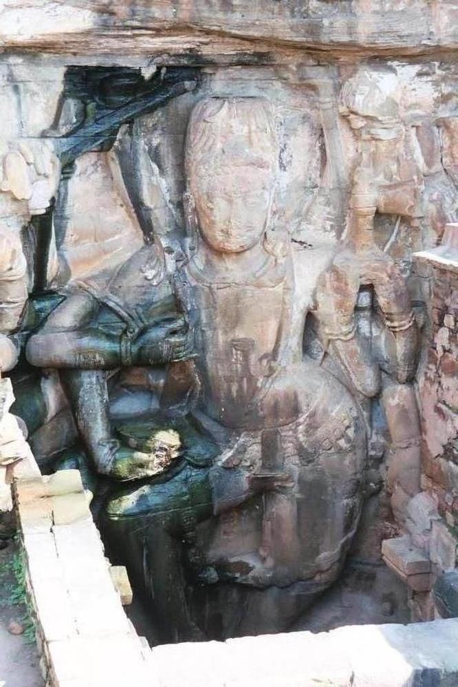 Nearby, a giant figure of a dancing Kali. Heads dangle from her belt.