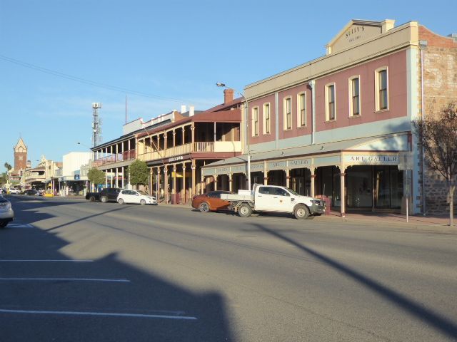 The building on the right was originally Walter Sully's Emporium, which opened in 1889 and was extended to the left in 1894. Sully sold heav