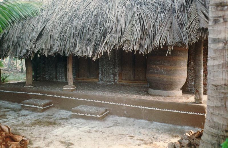 Deep in the Krishna Delta. The house is decorated with rice flour for pongal, a harvest festival. The cylindrical vessel is a rice store.