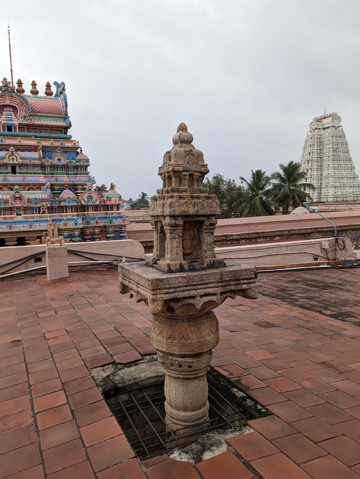 A dhvajastambha or flagstaff sticks through a recently built roof over the main axis.  On a scale of 1 to 10, the craftsmanship of the templ