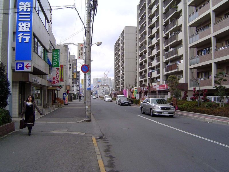 More apartments. The sign in the foreground is for a bank. The shop with the sign under the green one advertises American clothing.