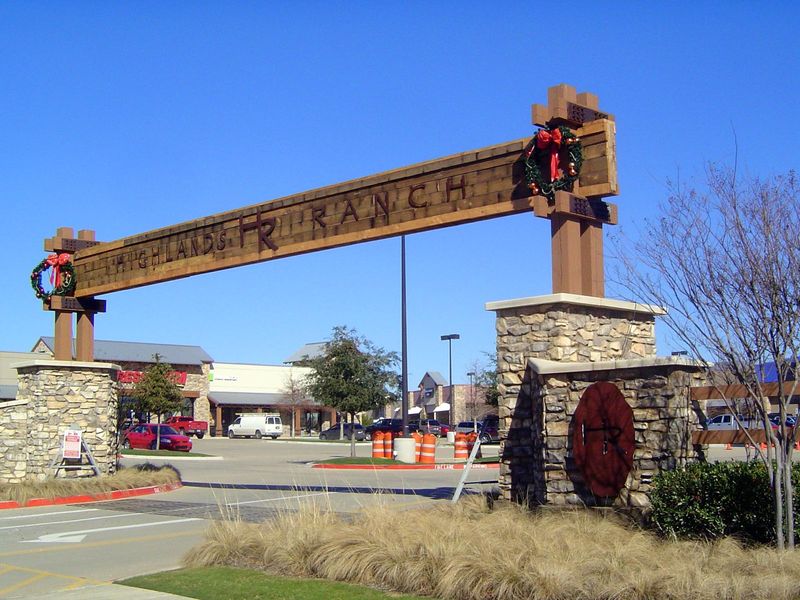 Here in Flower Mound, the Highland Ranch strikes an Imperial Texas motif. The strips of metal on the ground are a mock cattle guard and make
