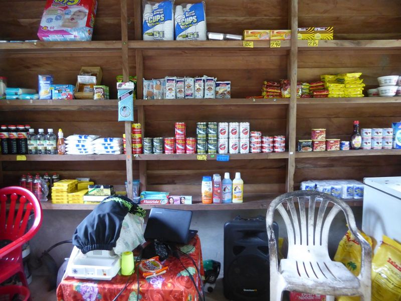Along with canned fish, spam, and toothpaste, the storekeeper has two computers.