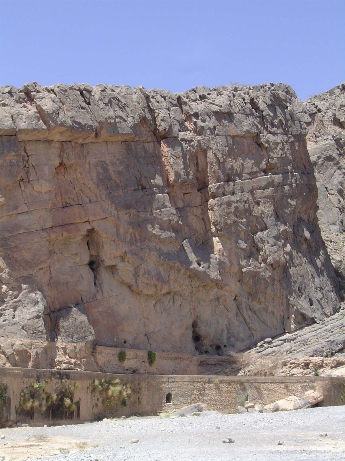 Nearby, a canal said to be 300 years old hugs the canyon wall behind a dry streambed.