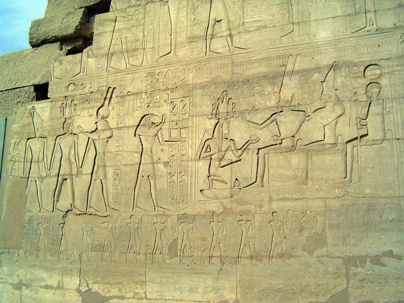 On the left, the king is escorted by Atum and Montu; on the right he kneels before them; below, the king's sons.