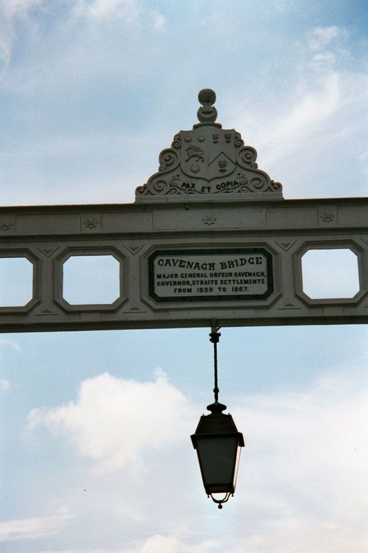 "Peace and wealth" is still an appropriate motto. The bridge is named for Orfeur Cavenagh, who was appointed as Governor of the Straits Sett