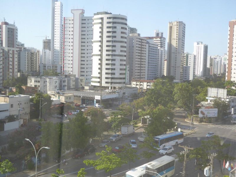 The view through an unfortunately sealed hotel window on Domingos Ferreira Avenue, a main street running parallel to the beach. Never forget