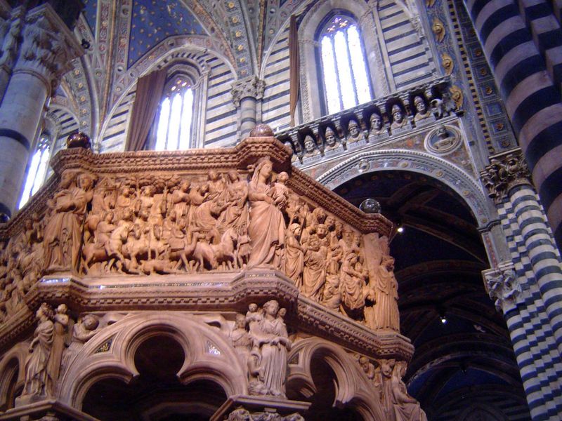 The carved marble pulpit, by Nicola Pisano, has panels showing the life of Christ, separated by angels and prophets; the lower level has the