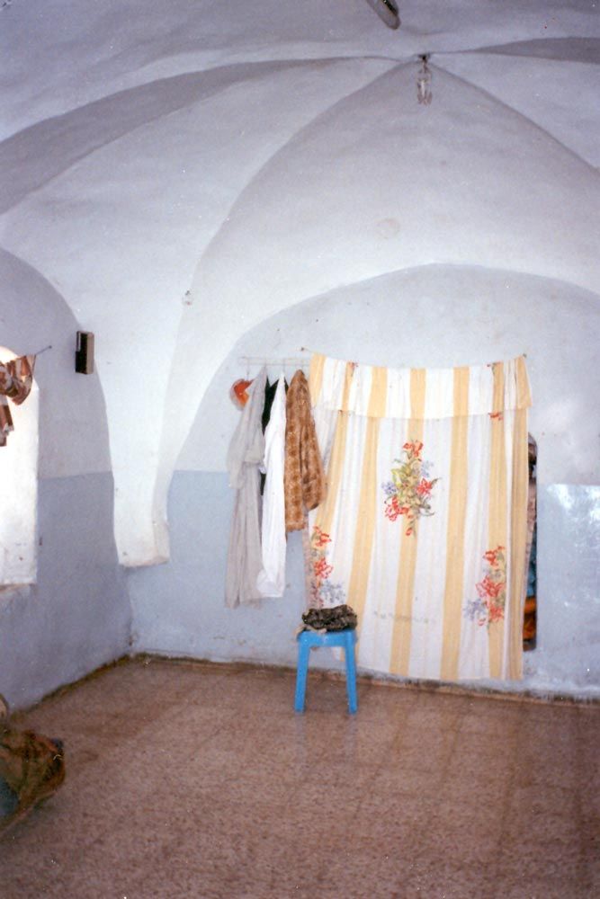 Nearby, there is an older home with a basement bedroom. All the bedding is folded up and stashed behind the curtain.