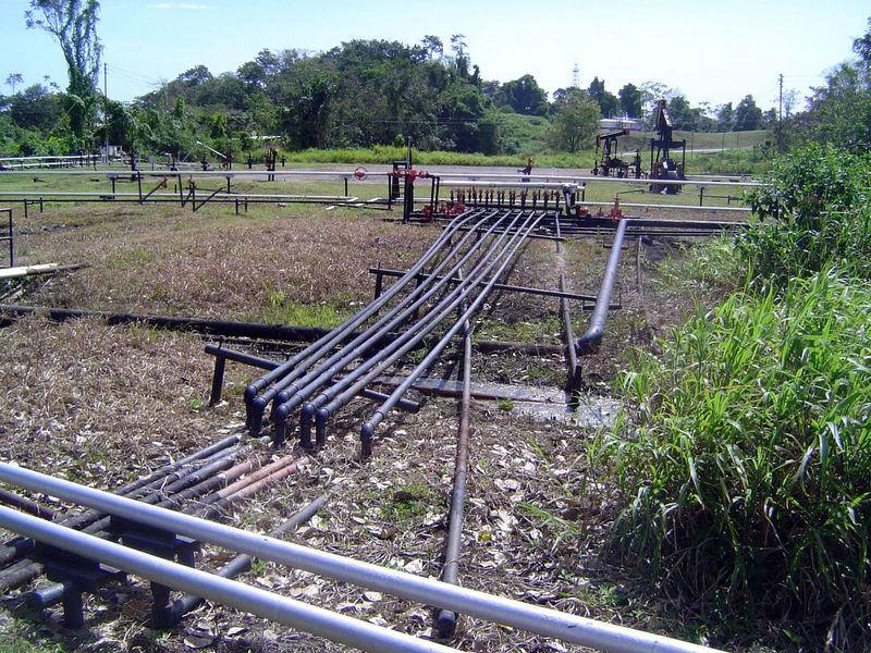 Oil wells and pipelines litter the surrounding landscape.