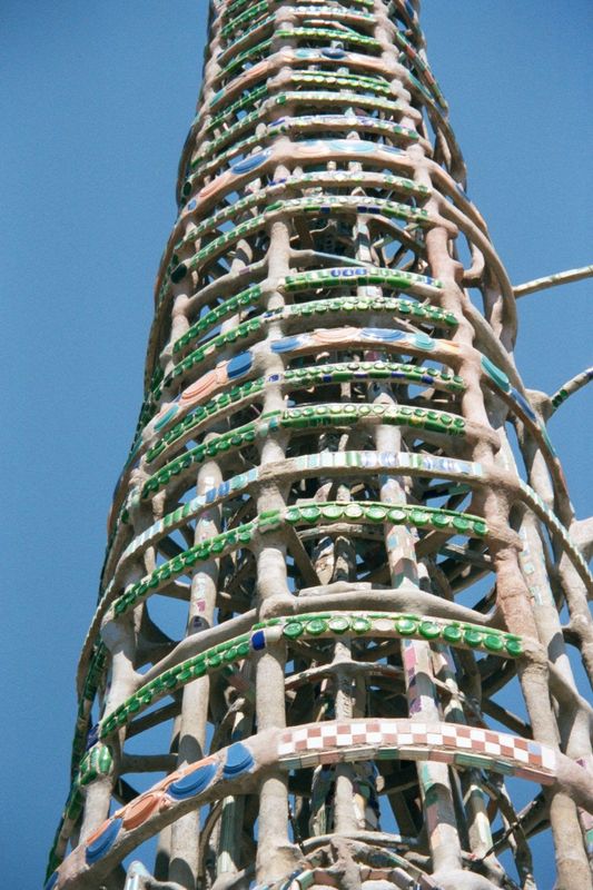 Five miles south of downtown, rings of glass from old 7-Up bottles brighten one of the Watts Towers. The towers are made of steel rods caked