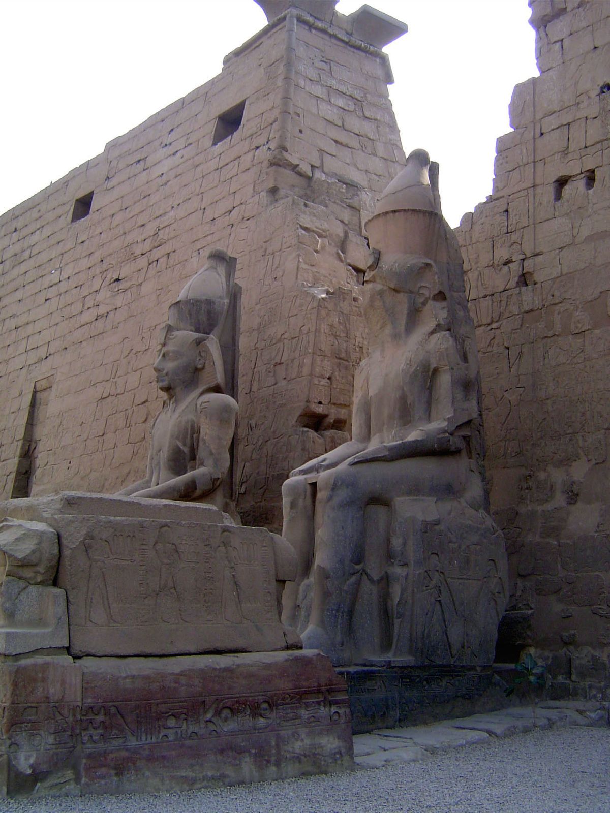 On the base of the colossal statues are two figures shown more closely in the next image.