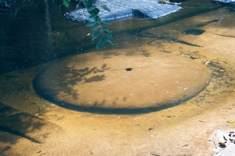 Above the waterfall, and carved in the sandstone streambed, there's a low lingam, nested in a square yoni. The lingam is Shiva's symbol, and