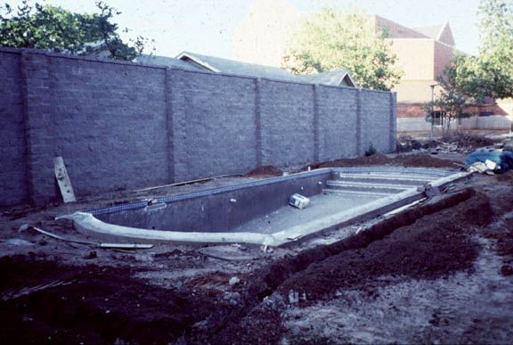 Close to the university campus, a swimming pool goes in the back yard of a house. It needs to have a security wall, and the owner sets about