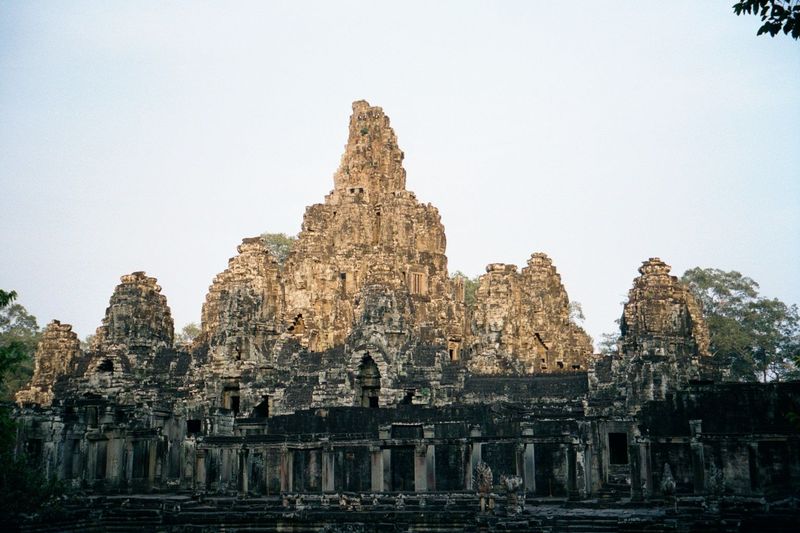 The Bayon, built a century after Angkor Wat, was much modified in succeeding centuries. It is a three-deck pyramid, but the tower-rimmed sec