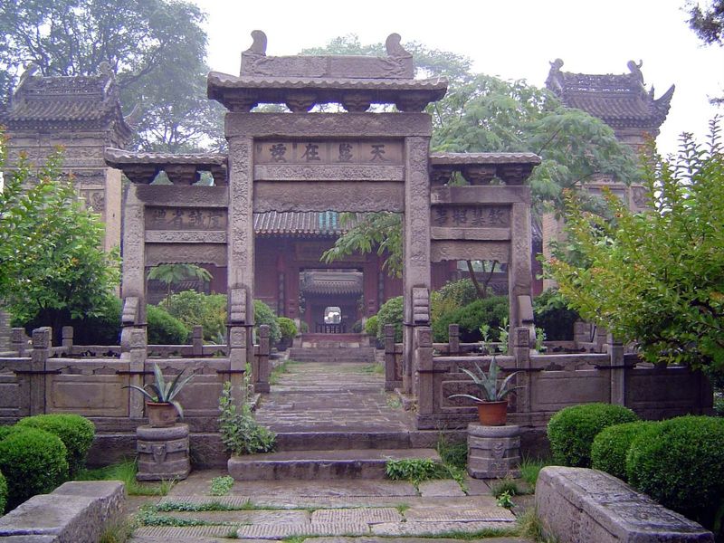 Stone gateway with tablet pavilions rising behind it on either side.