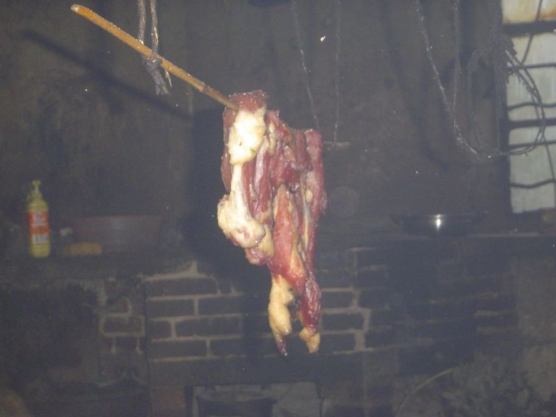 Besides filling the house with smoke, the little fire also smokes bits of last year's pig.
