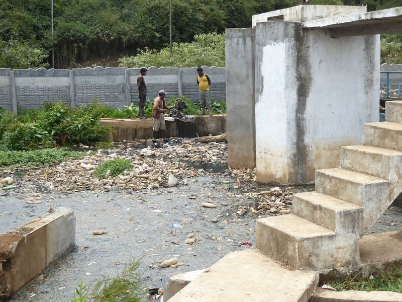 At the lake outlet, a crew forks out accumulated trash.