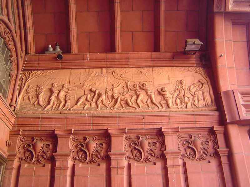 The entrance is decorated with scenes from the life of John Wesley. The event shown here is a rectory fire in 1709. Here's Wikipedia on the 