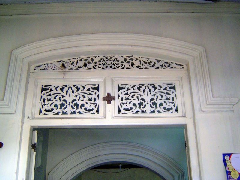Beyond the veranda, there's a doorway into another room. A decorative lattice provides some ventilation.