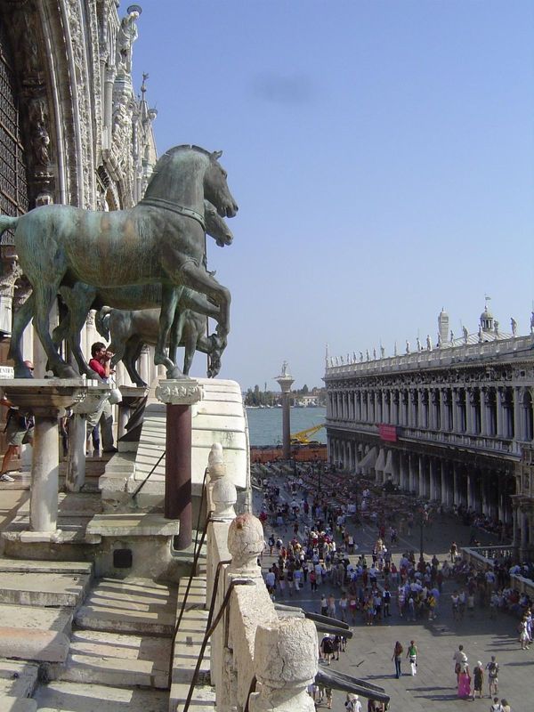 We're up on a balcony in the basilica and looking over an edge of the sunny piazza, as well as the shaded piazetta. The horses are modern co