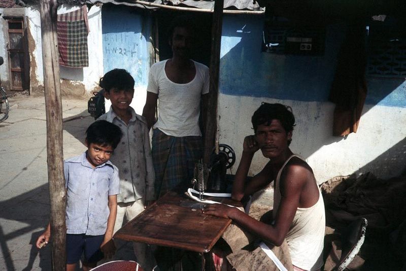 A village tailor, with a treadle-powered sewing machine.