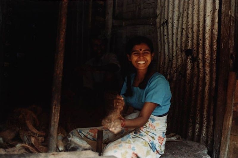 One source of local income: an Indian girl using a hammer to break coconuts—hundreds of coconuts, mountains of coconuts.