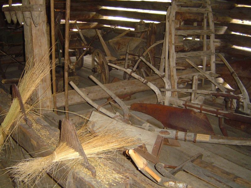 Behind the house is a large barn filled with implements.