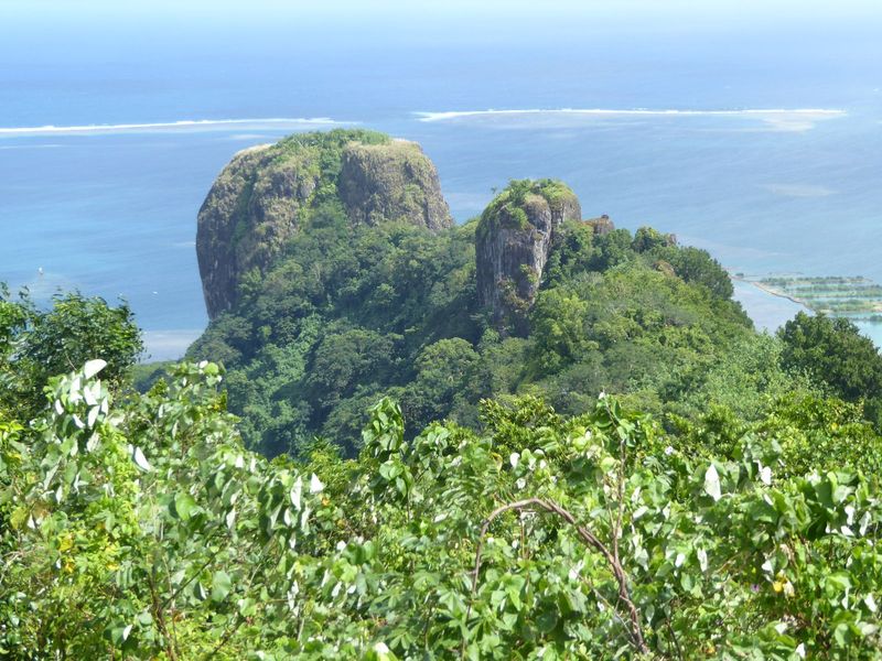Here's the same rock from the other side. The island's coral-reef necklace is on display, along with two of the several natural breaks in th