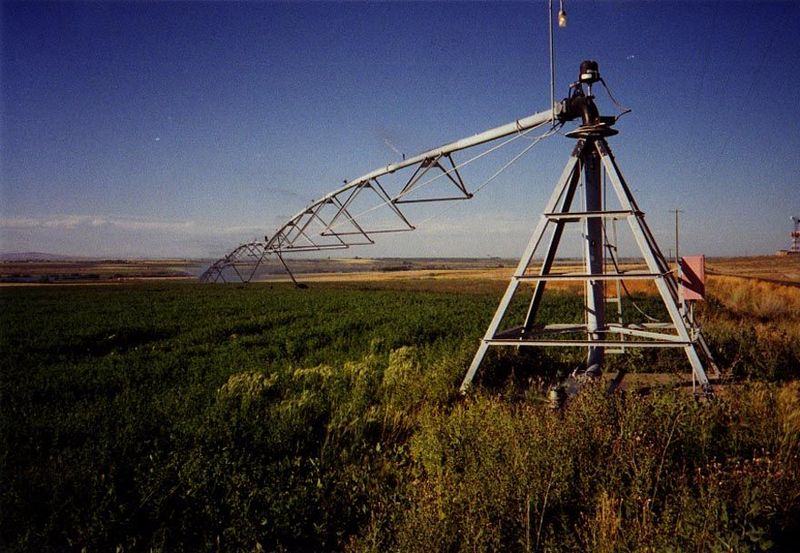Back in the states, this time in Idaho, a center pivot swings across a field of potatoes. A long way from second homes. Note the tiny discha