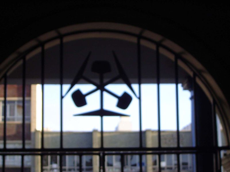 A neat railway emblem survives in a deserted waiting room.