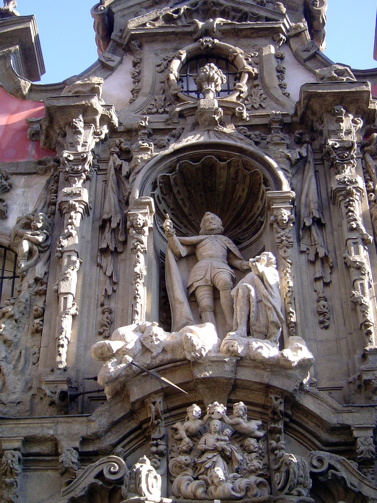 The facade is like an altarpiece focused on San Fernando, whose mundane name was Ferdinand II of Castile. He was the conqueror of Seville an