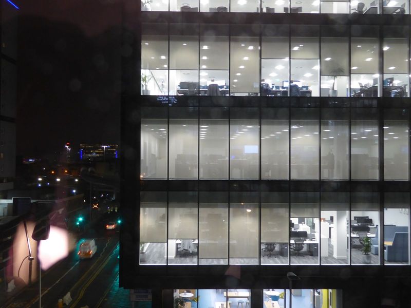 A night-time view of a neighboring investment bank, with a couple of bankers still crunching those numbers.