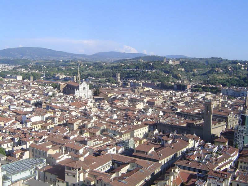 If we swing to the south, the tower of the Bargello comes into view. In the background, atop a hill, is the Church of San Miniato al Monte, 