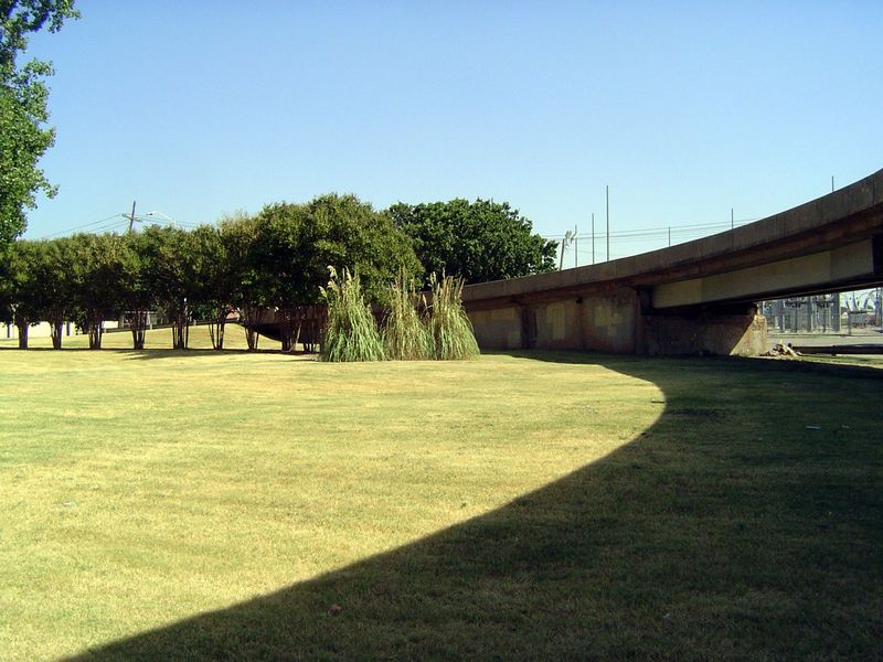 The landscaping on a corkscrew freeway entrance was still being maintained.