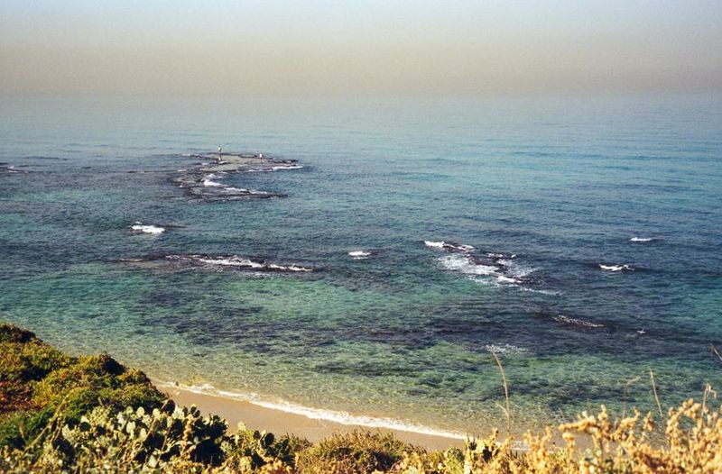 The hazy view from Jaffa west toward Andromeda's Rock. Through the 19th century, this was the very rough port of Palestine, with landings by