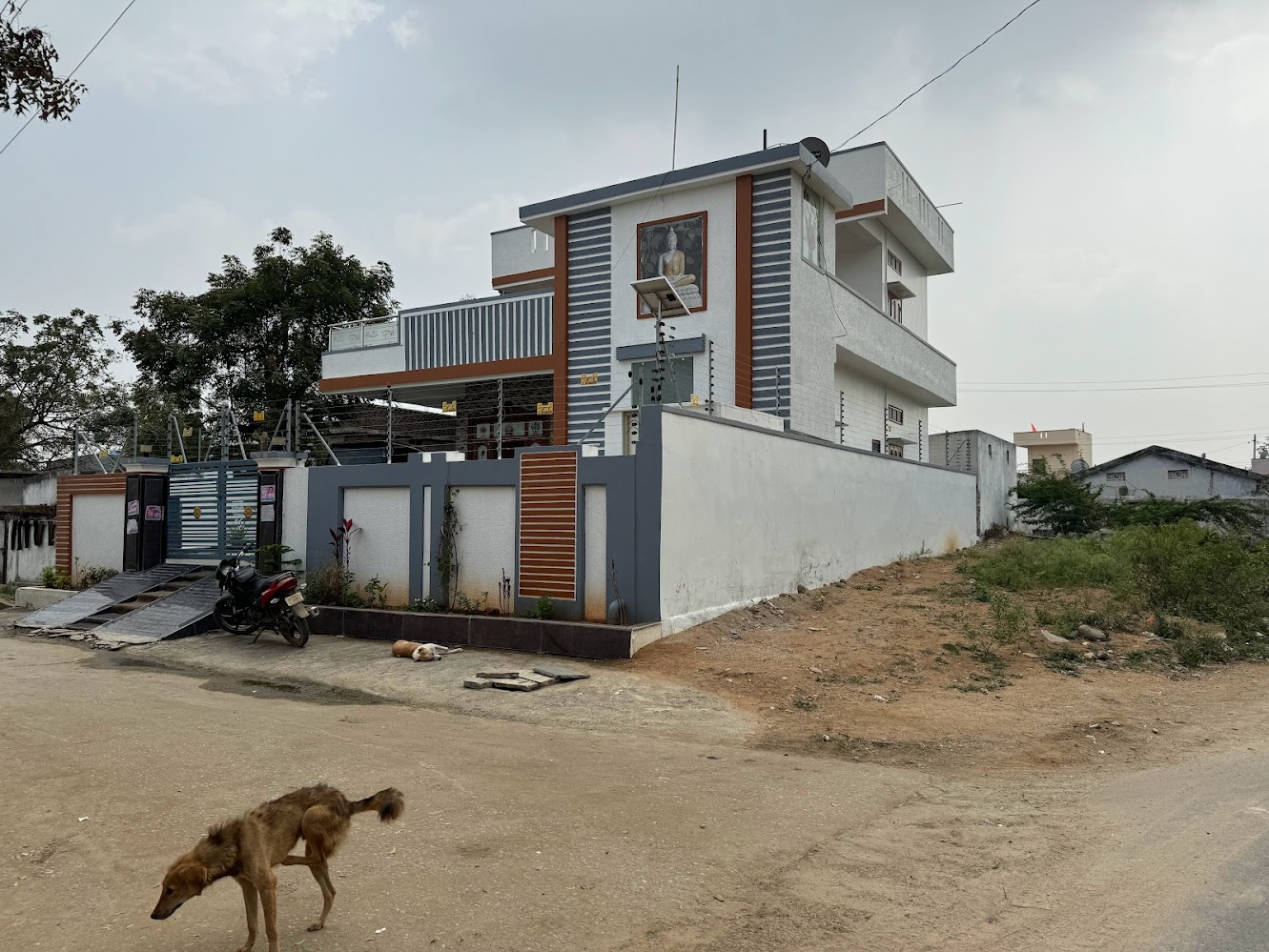 One of the flashier houses in the village.  Plenty of signs of the Buddha, along with electric fencing and a starving dog.