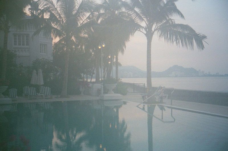 The hotel pool fronts the seawall, where a line of highrise apartments can be detected along the distant skyline.