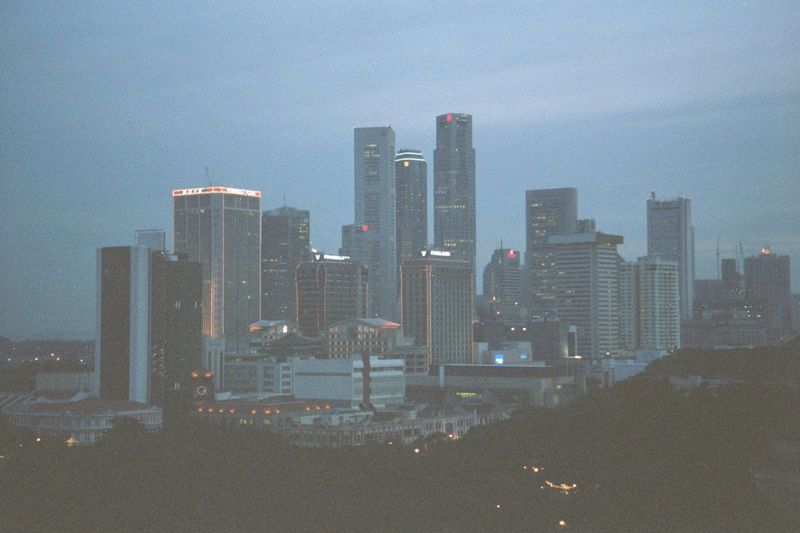 The upshot: downtown at dusk, January 2001. That's a densely forested park in the foreground. The Singapore River winds just this side of th