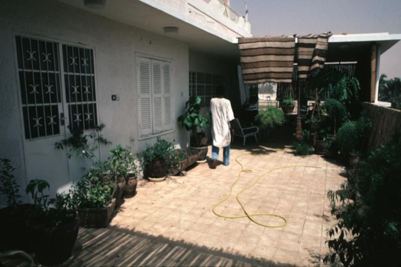 The upstairs patio of one such home, screened with bamboo and watered daily against the severe sun.