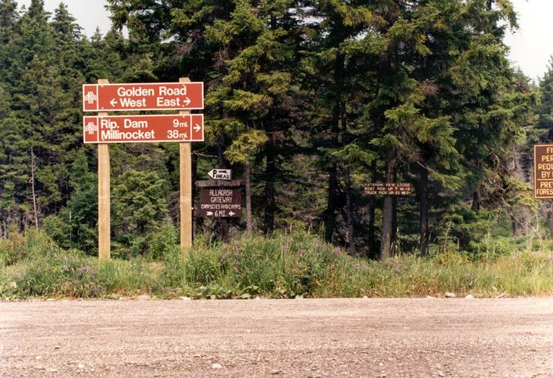 The roads through this part of Maine are private, though the landowners permit controlled public access. The stylish red signs here are on t