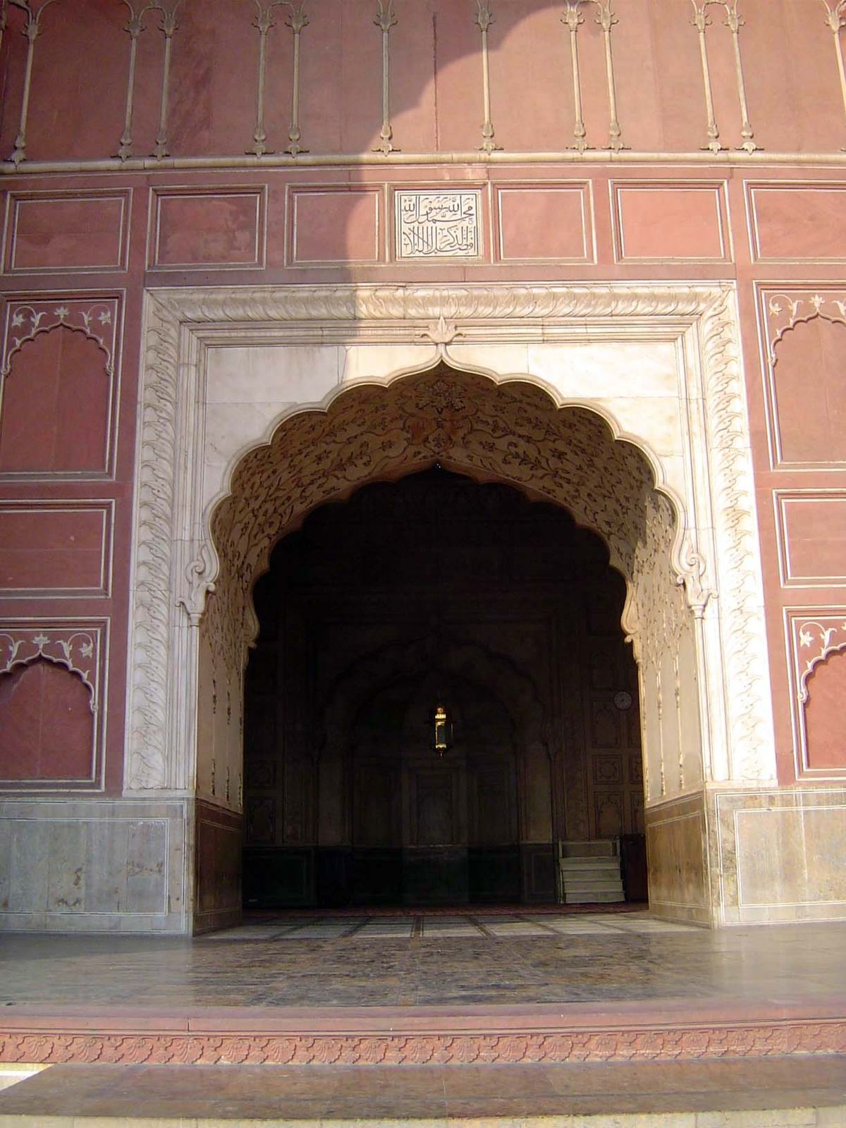 Engrailed marble arches in a wall of minimally decorated sandstone panels. Compare it with Wazir Khan's mosque, also in Lahore. There, compa