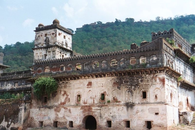 The abandoned palace of the local rajah. A newer one, inhabited, is nearby. Above, on the hillcrest, are the ruins of Ajaigarh fort, reached