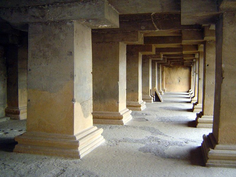 In the back wall, a massive hypostyle hall leads into the excavated cave.