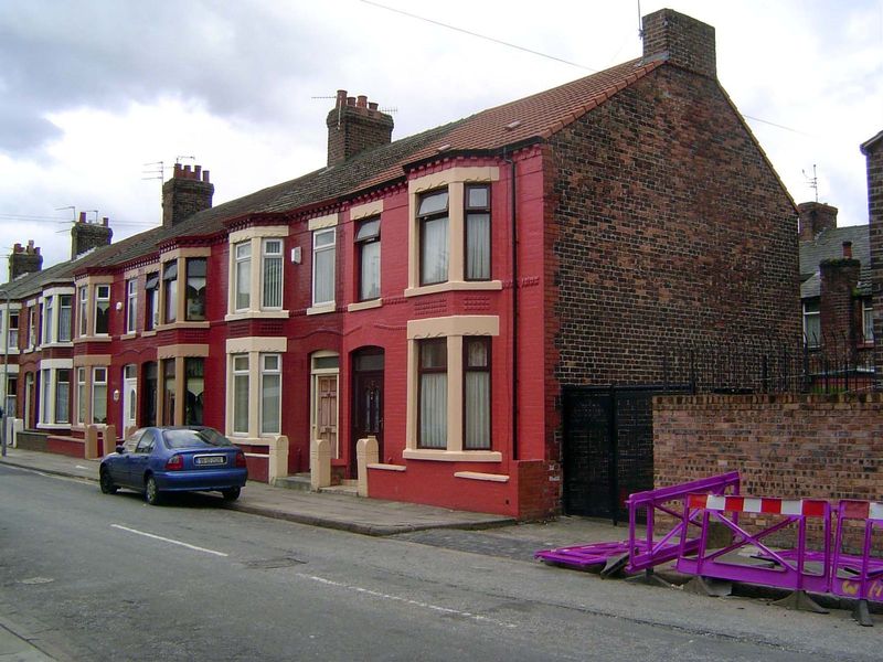 These houses are typically built on blocks that are long and narrow, with four lines of houses, two long and two short. The black gate is th