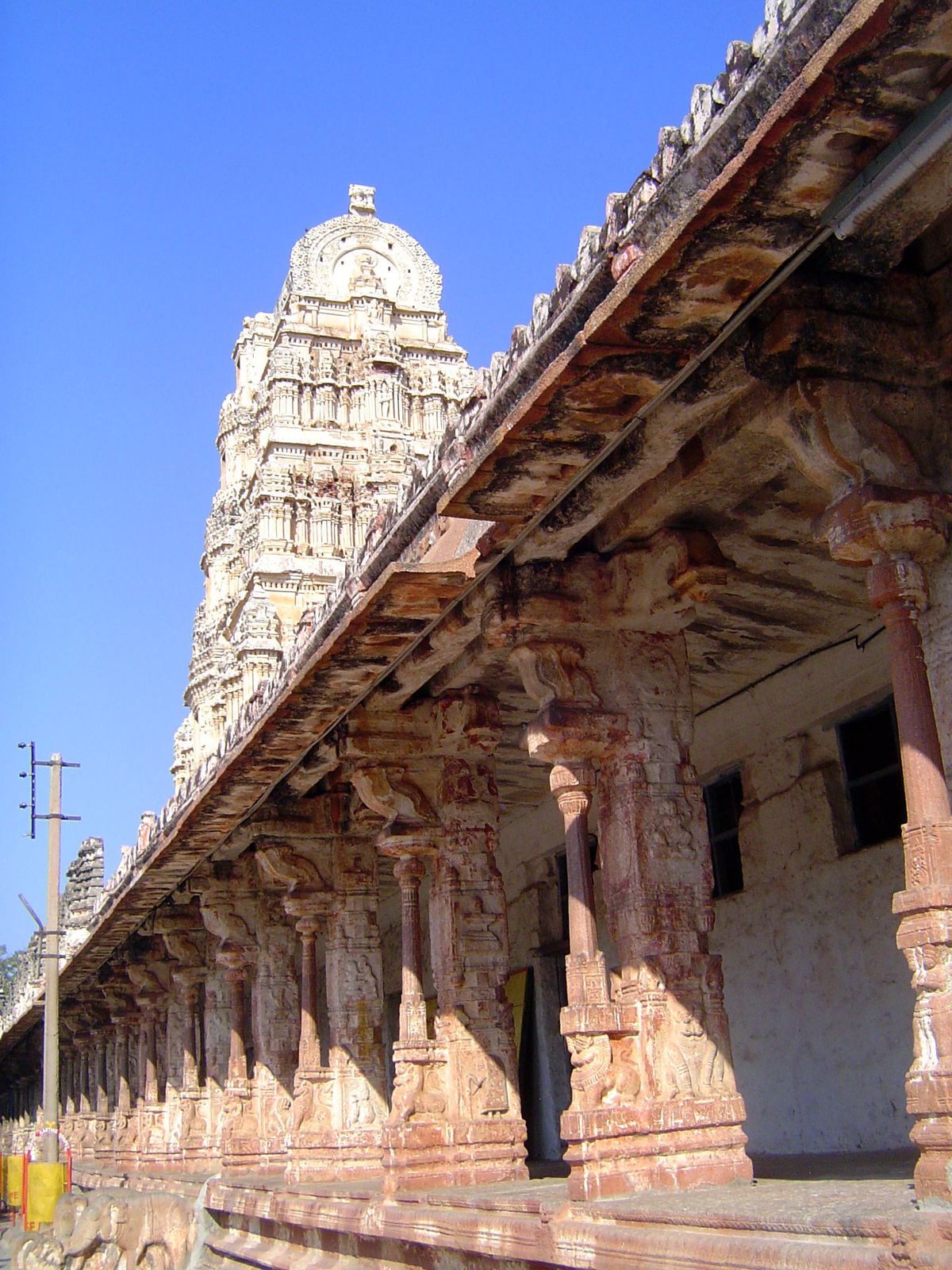 A second courtyard opens. The detached colonettes on each pillar are a standard feature at Vijayanagar.