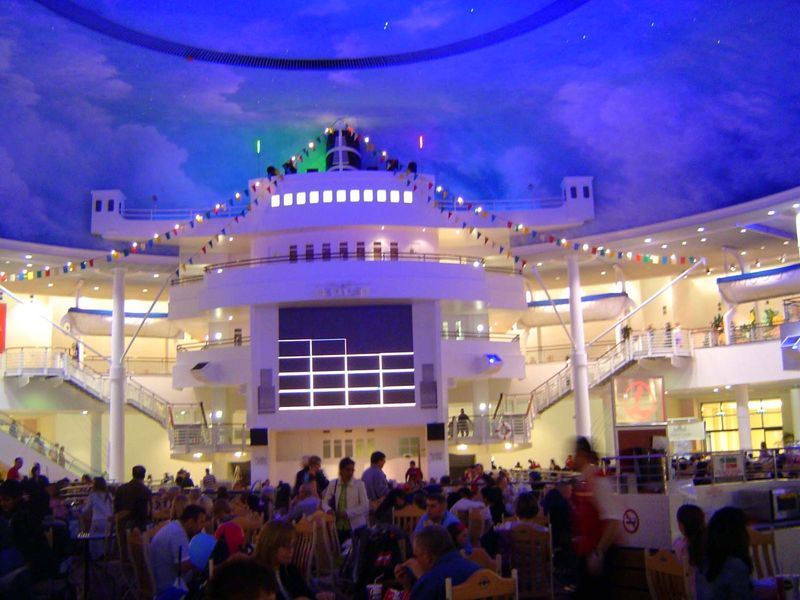 You don't believe me? But where are we? Could it be the Normandie, bound for Le Havre? Ah, no, it's the Trafford Mall food court.