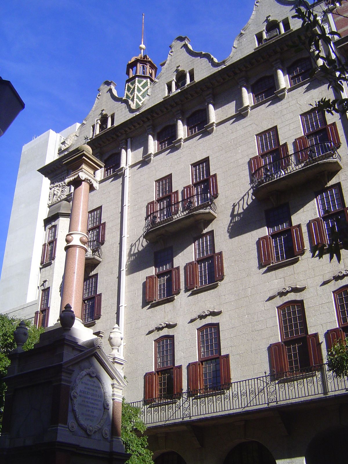 The same building, facing a granite monument to Robert Gray, first bishop of Cape Town.